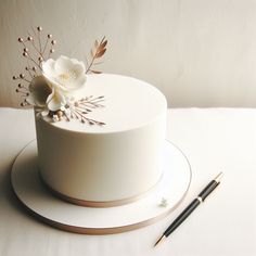 a white cake sitting on top of a table next to a pen