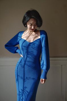 a woman in a blue dress posing for the camera