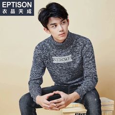 a young man sitting on top of a wooden stool wearing a sweater and black pants