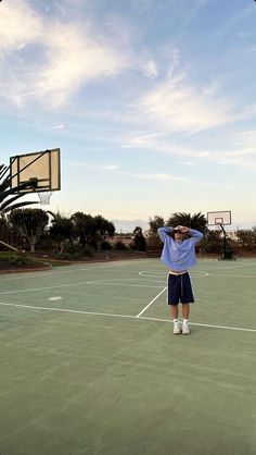 a man standing on top of a tennis court holding his hands up to his head