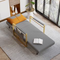 a bed sitting on top of a gray rug next to a table with an open book