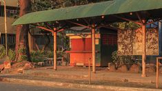 an old bus stop sitting on the side of a road in front of a building