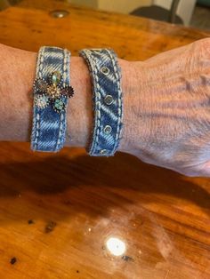 an older woman's arm with two bracelets on it