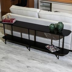 a living room with a white couch and black coffee table