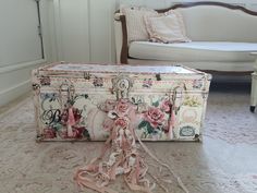 an old trunk is sitting on the floor in front of a white couch and chair