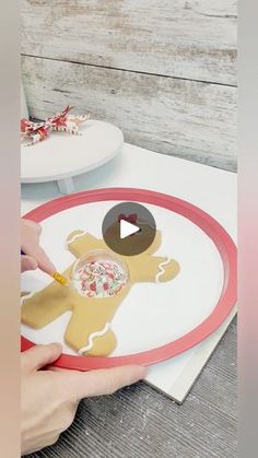 someone is cutting out a gingerbread man on a paper plate