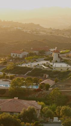 an aerial view of houses and windmills in the distance