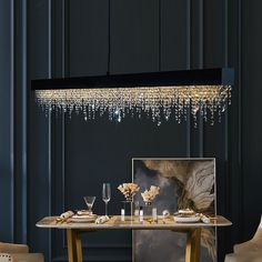 a dining room with a table, chairs and a chandelier hanging from the ceiling