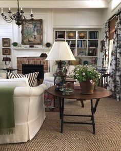 a living room filled with furniture and a lamp on top of a table in front of a fire place