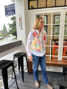 a woman is standing on the porch with her hand in her pocket