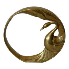 a brass swan sculpture sitting on top of a white surface