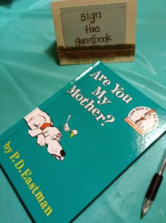 a book and pen sitting on top of a blue tablecloth covered table with writing