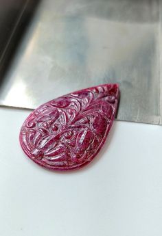 a red piece of food sitting on top of a white counter