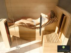 a woman laying down in a wooden sauna