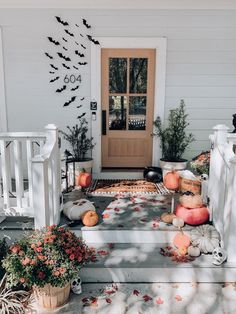 a porch decorated for halloween with pumpkins and other decorations