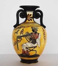 a vase with an image of a man playing the lyragonic instrument on it