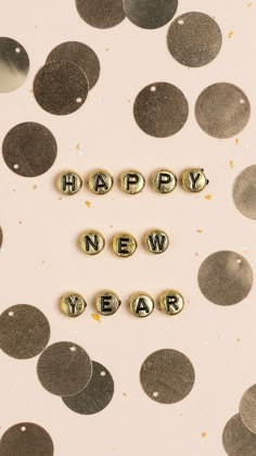 the word happy new year spelled out in gold letters on a white background with confetti