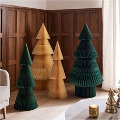 three wooden christmas trees sitting next to each other in front of a window on the floor