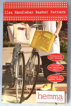 the front cover of a magazine with a woman standing next to a bicycle and shopping bags