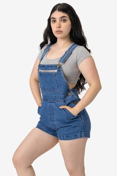 The Denim Cuffed Short All is made of our rigid 14 oz. denim made of 100% US-grown cotton. These short alls have a relaxed fit and adjustable straps for an easy, comfortable fit. This style features side pockets, back pockets, and a chest pocket with zip so you can store all the belongings you need on the go without having to worry about losing anything. Dress these overalls up by layering with a turtleneck or sweater and tights in the winter, and pair with our classic baby tees and crop tops fo Fitted Denim Shortalls In Dark Wash, Casual Dark Wash Denim Shortalls, Short Overalls Denim, Dark Wash High Rise Denim Shortalls, Casual Short-length Denim Overalls, Bus Pass, Cuffed Shorts, Small Waist, Above The Knee