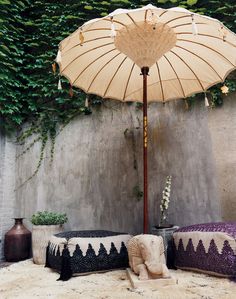 an umbrella and some pillows in front of a wall