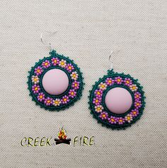 These are authentic Native American earrings, hand crafted by a member of the Muskogee Creek Tribe. Used in the handmade process are seed beads, acrylic cabochons and faux leather backing. The bead colors included in this pair are: alabaster yellow, teal green , pink and purple seed beads. They measure 2 inches wide and 1 1/2 inches long. They have stainless steel hypo-allergenic hooks for pierced ears. Beaded Earrings Native 1stdibs, Beaded Studs Earrings, Beaded Earrings Native Beadwork Ideas, Beaded Earrings Native Beadwork, Beaded Native Earrings, Muskogee Creek, Cab Earrings, Creek Tribe, Native American Beadwork Earrings