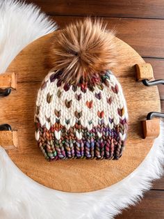 a knitted hat sitting on top of a wooden board