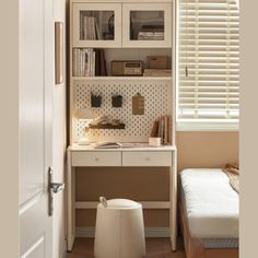 a bedroom with a bed, desk and bookcase in the corner next to a window