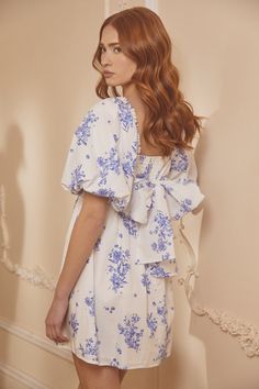 Whether you're sipping tea or rehearsing for the big day, this dress is your go-to. With oversized puff sleeves that pack a punch, they frame a square neckline and a fitted bodice with princess seams. Just below, a flared mini skirt creates a balanced feel, while the back features smocking with a large tie design. Take the look from casual to dressy and swap out the shoes. Pair it with your favorite jewelry for a completed fun look.- Oversized sleeves- Smocked back- Tie back detail- Poplin- Colo Summer Bishop Sleeve Dress For Brunch, Summer Brunch Dress With Bishop Sleeves, Summer Garden Party Dress With Bishop Sleeves, White Floral Print Dress With Bishop Sleeves, White Dresses With Floral Print And Bishop Sleeves, Blue Billowy Dress With Puff Sleeves, Blue Balloon Sleeve Dress For Spring, Blue Dresses With Ruffles And Balloon Sleeves, Blue Balloon Sleeve Dress For Brunch