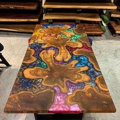 a table made out of wood with different colors and shapes on it, sitting in front of some benches