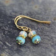 These handmade Ethiopian opal earrings are dainty yet exotic - they simply glow and will light you up with their fabulous opalescence. Featuring an exquisite Ethiopian 'Welo' opal sat above a gorgeous aqua glass bead, with a gold bead nestled between. These opals are the finest quality, flawless, AAA with superb inner fire - they catch the light with every movement and the rainbow of colours is quite mesmerizing. Very dainty, these iridescent drop earrings measure just 2.2cm from top to tail. Fi Handmade Opal Drop Earrings, Iridescent Drop Earrings With Matching Jewelry, Iridescent Drop Earrings With Matching Jewelry Set, Iridescent Jewelry With Matching Drop Earrings, Iridescent Drop Earrings For Jewelry Making, Iridescent Drop Earrings Jewelry Set, Handmade Iridescent Earrings With Round Beads, Handmade Iridescent Round Bead Earrings, Bohemian Iridescent Jewelry With Ear Wire