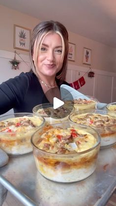 a woman sitting at a table with several pies in bowls on top of it