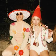 two people dressed in costumes sitting on the ground