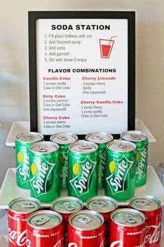 a table topped with lots of soda cans next to a sign that says soda station