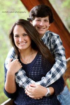 a young man and woman hugging each other