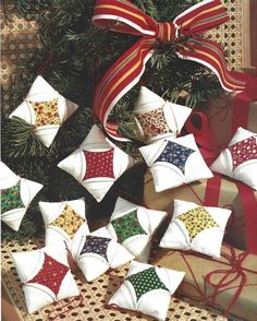 a bunch of christmas ornaments sitting on top of a table next to a red ribbon