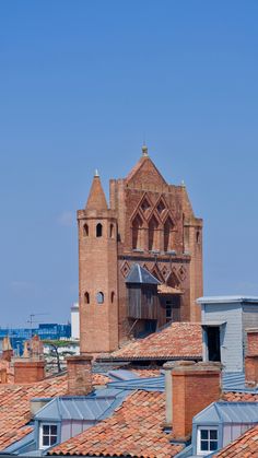 an old brick building with a clock tower in the middle of it's roof tops