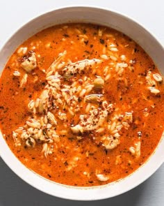 a white bowl filled with red soup on top of a table