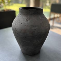 a black vase sitting on top of a table