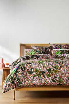 a bed with colorful floral comforter and pillows