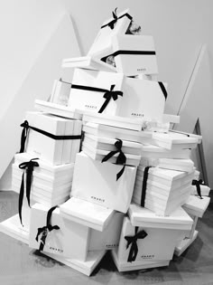 a stack of white boxes with black ribbons tied around the top and bottom, all stacked on each other