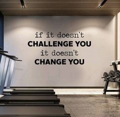 an exercise room with treadmills and wall decal saying if it doesn't challenge you, it doesn't change you