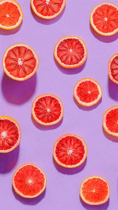 grapefruit cut in half on purple background