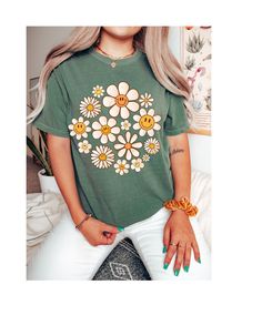 Step into the warmth of style and embrace the carefree vibes with our "Daisy Days Sunshine Bloom Tee." This delightful t-shirt is a celebration of the spirit of warmer days and sunny moments. Crafted from soft, breathable cotton, it provides comfort that matches its sunny disposition. The cheerful design features a vibrant daisy in full bloom, symbolizing the positivity and brightness that comes with the arrival of warmer weather. The playful colors and lively imagery make it a perfect addition Trendy Soft-washed T-shirt For Spring, Funny Print Tops For Spring Loungewear, Trendy Smiley Face Tops For Loungewear, Trendy Floral Print T-shirt For Day Out, Trendy Smiley Face Loungewear Tops, Funny Print Tops For Summer Loungewear, Smiley Face Top For Loungewear, Casual T-shirt With Daisy Print For Spring, Hippie Soft-washed Relaxed Fit Tops