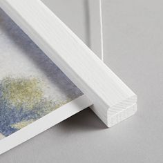 a close up of a white frame on a gray surface with yellow and blue paint