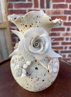 a white vase sitting on top of a wooden table