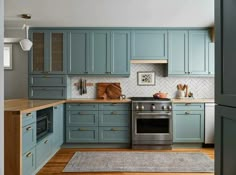 a kitchen with blue cabinets and wood floors