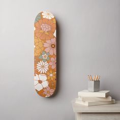 a skateboard mounted to the side of a wall next to a stack of books