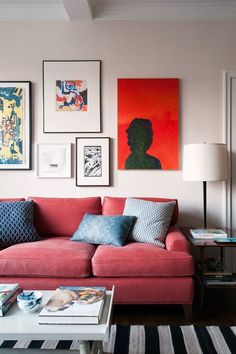 a living room filled with furniture and pictures on the wall above it's coffee table