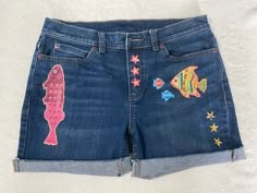 PLEASE READ: These cut-offs are handcrafted and each item is unique. No two items will be alike! If you don't see your size in a specific design, I have a large stock of plain inventory that can be made individually just for you!!  Themes are cocktail, flamingos, palms, tropical fish, tropical flowers, turtles, and peace. If you don't see your size and theme, message me.  I can make a pair per your request!! This pair - tropical fish design, has the following dimensions: Size - 6 US Inseam - 5" Jean Shorts With Designs, Spring Patchwork Denim Jean Shorts, Patchwork Jean Shorts, Summer Patchwork Jean Shorts, Fish Shorts, Painted Jean Shorts Pockets, Silly Clothes, Brunch Fashion, Patchwork Clothes